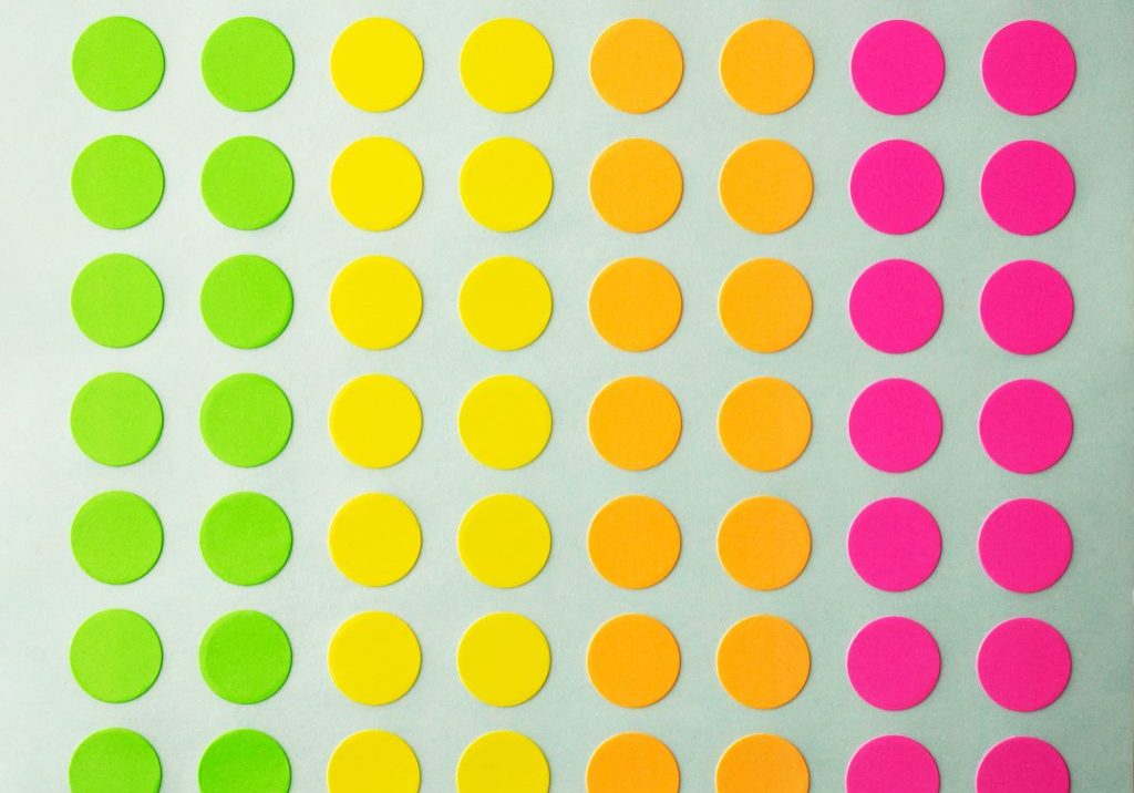 Sheet of circle labels or dot sticker in various neon colors. also called coding Dot Labels. Close-up macro from above.